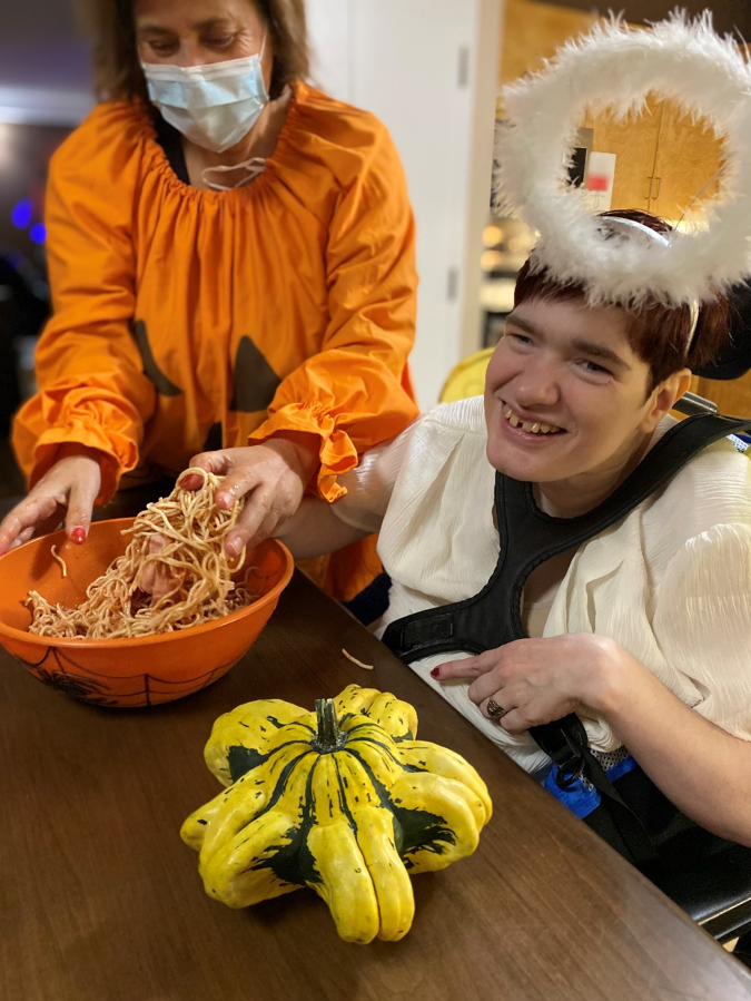 Tracy exploring Halloween sensory fun, feeling “wet slippery brains”.