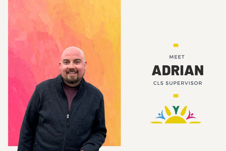 Pink and yellow chalk-like background behind picture of man wearing black. The words "Meet Adrian CLS Supervisor" on the right side with two yellow rectangles on the top and bottom of the text. Sunbeam Community Services yellow sun with pink and blue accents logo at the bottom of the page on right side.