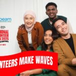 Group of four individuals smiling, Sunbeam Community and Developmental Services logo on the top left, over the National Volunteer Week 2025 logo. "Volunteers Make Waves" on a red ribbon-like banner.